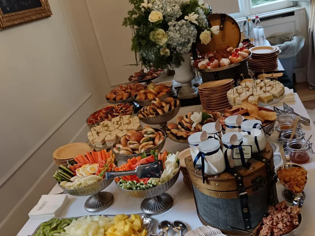 Buffet ricco di taglieri, cesti di pane e vassoi di finger food