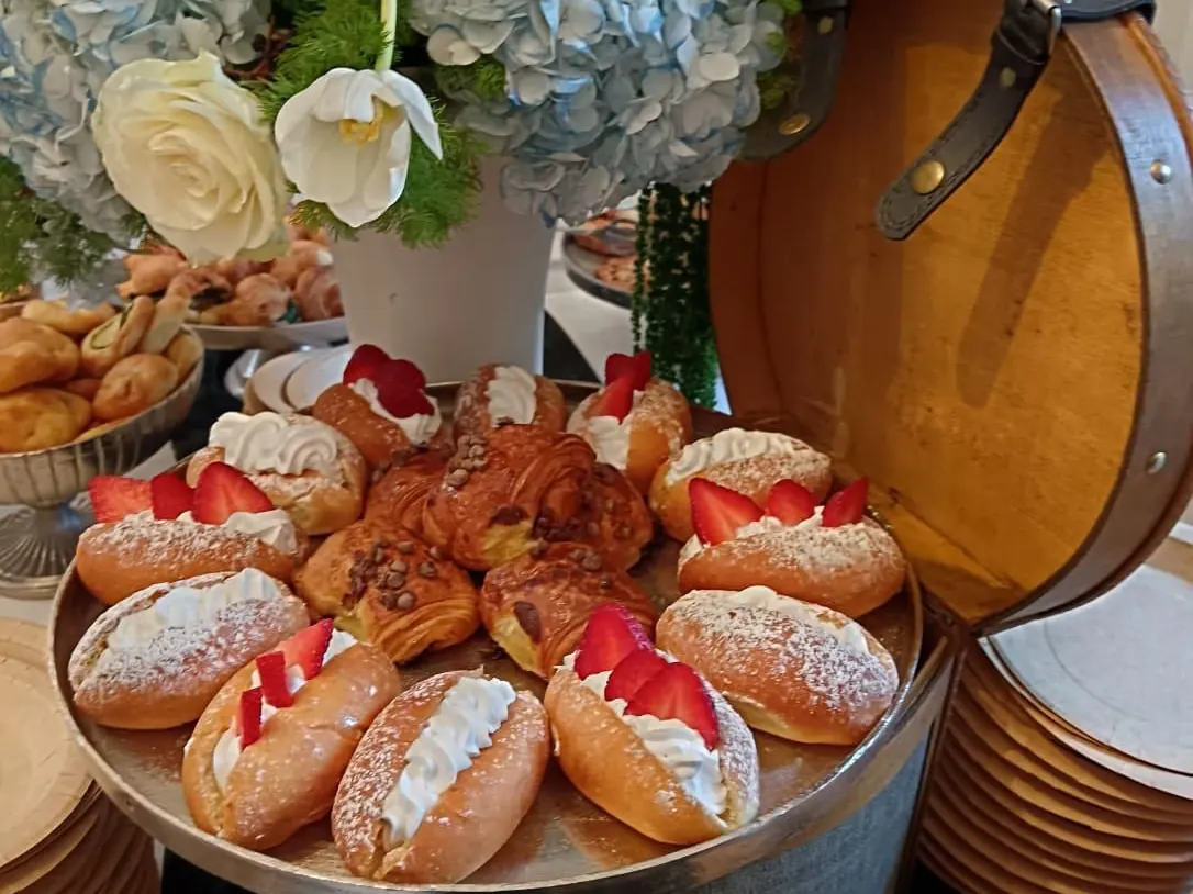 Primo piano di pasticceria fresca con fragole e crema su alzate di metallo