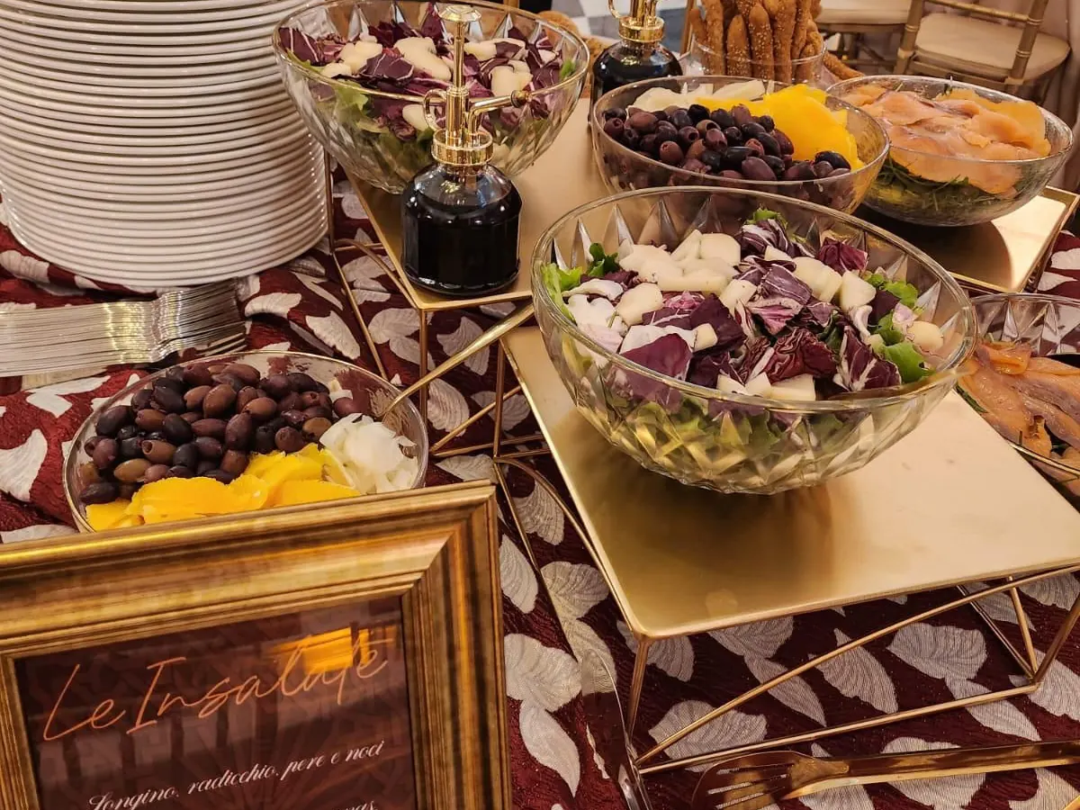 Coppe di insalate, olive e verdure su una tavola apparecchiata