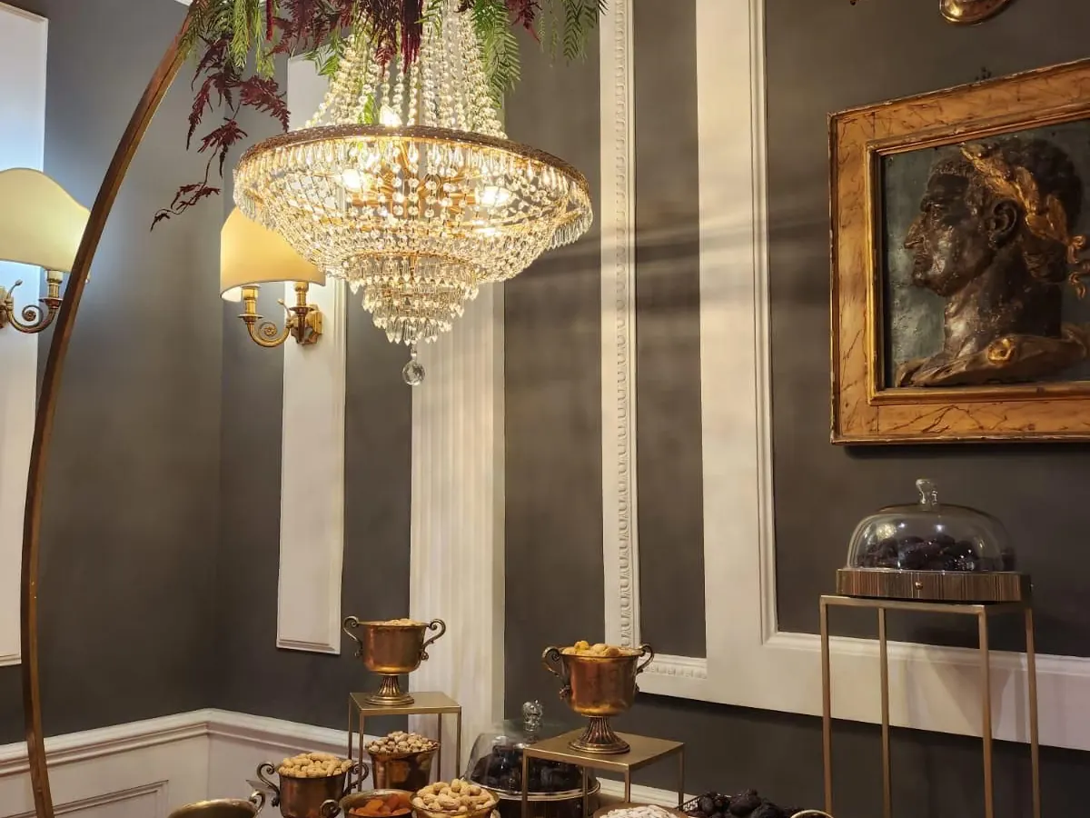 Sala interna con lampadario di cristallo e buffet di frutta secca in coppe di ottone